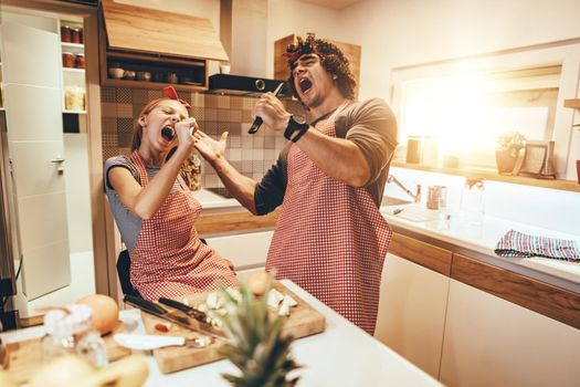 Happy father and his daughter enjoy and having fun in making healthy meal together at their home kitchen.