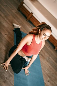 Beautiful young woman doing stretching exercises at home.