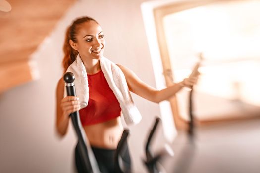 Beautiful young woman exercising on stepper at  home.