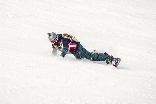 Young man with snowboard enjoying a winter day on mountain slopes.