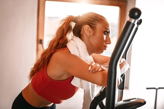 Attractive woman is exhausted and taking a break from hard exercising in living room at home.