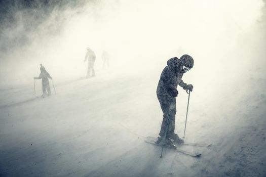 Young man rides snowboard and enjoying a frozen winter day on mountain slopes.