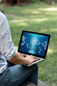 Woman Typing On Laptop Sitting Outside Side View Working From Home.