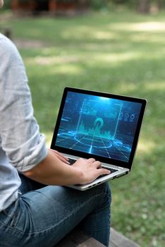 Woman Typing On Laptop Sitting Outside Side View Working From Home.