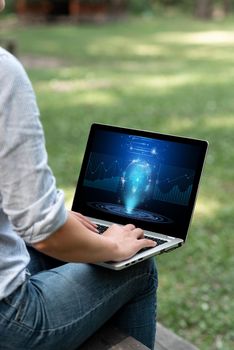 Woman Typing On Laptop Sitting Outside Side View Working From Home.