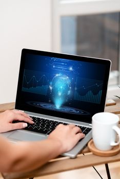 Both Hands Typing On Laptop Next To Cup And Plant Working From Home.