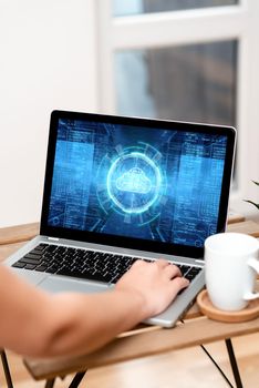 Hand Resting On Laptop Top Of Table Beside Cup Working From Home.