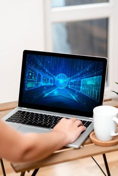 Both Hands Typing On Laptop Next To Cup And Plant Working From Home.