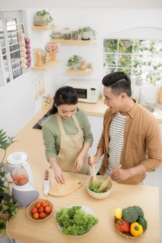 Happy young couple cooking in the kitchen. Top view