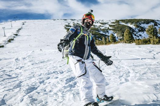 Young man rides snowboard and enjoying a frozen winter day on mountain slopes.