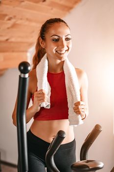 Beautiful young woman exercising on stepper at home.