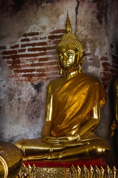 Golden Buddha beside old walls in Thai temples