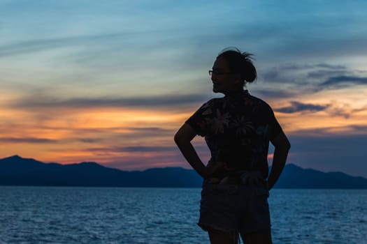 Silhouette of a woman standing and watching the sunset