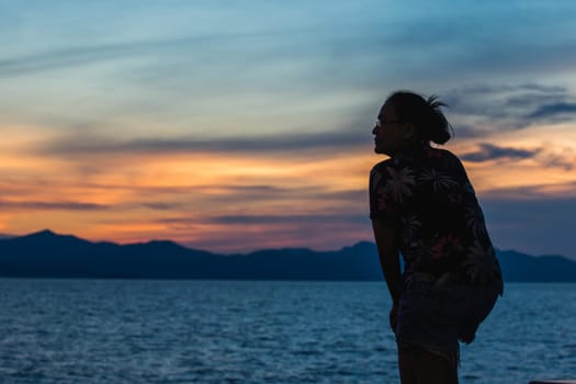 Silhouette of a woman standing and watching the sunset