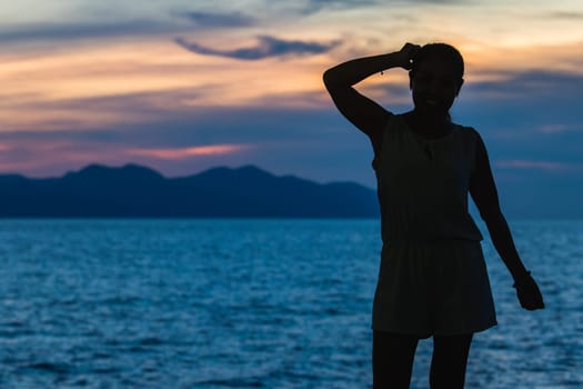 Silhouette of a woman standing and watching the sunset