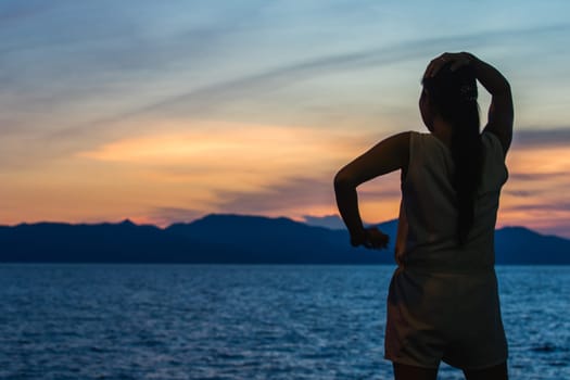 Silhouette of a woman standing and watching the sunset