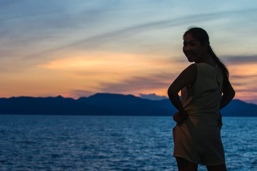 Silhouette of a woman standing and watching the sunset