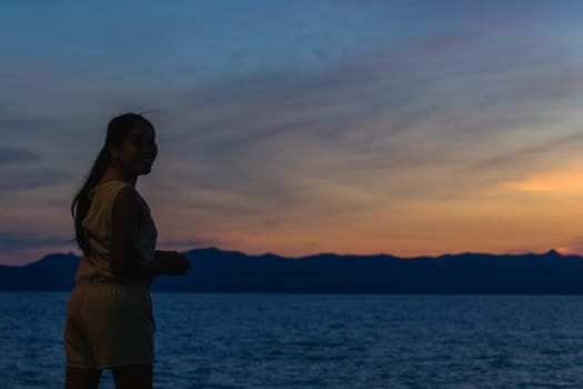 Silhouette of a woman standing and watching the sunset