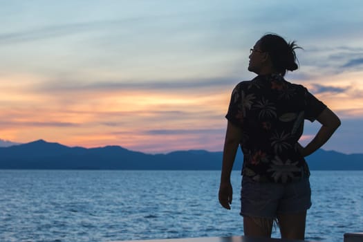 Silhouette of a woman standing and watching the sunset