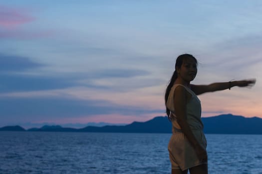 Silhouette of a woman standing and watching the sunset