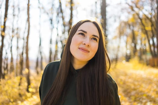 Beautiful smiling woman walking outdoors in autumn