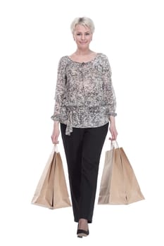 in full growth. elegant young woman with shopping bags striding forward . isolated on a white background.