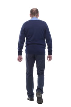 mature man in blue jumper striding forward. isolated on a white background.