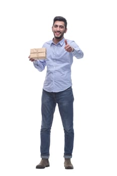in full growth. happy young man with a gift in craft-paper. isolated on a white background.