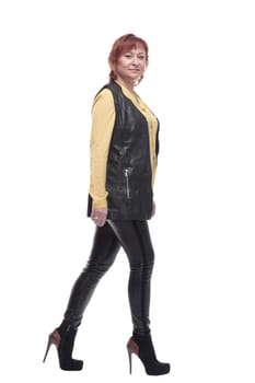 mature woman in leather trousers striding forward. isolated on a white background.
