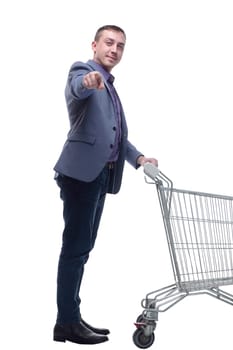 Full length view of handsome young man standing with shopping trolley and looking at camera isolated on white