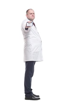 in full growth. competent doctor showing his visiting card. isolated on a white background.
