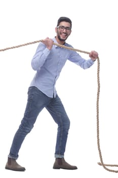 in full growth. purposeful young man pulls the rope. isolated on a white background.