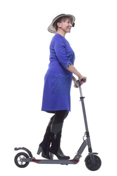 Full length profile shot of an woman with a scooter isolated on white background wearing a blue dress and a hat