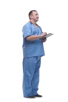 side view. serious doctor making notes in the clipboard. isolated on a white background.