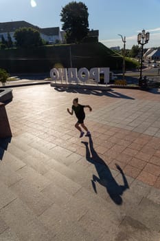 A young woman in black clothes running on stairs at city street early morning.