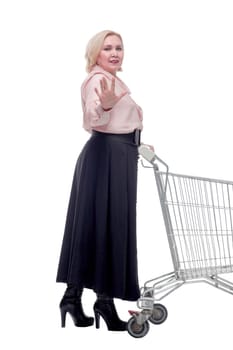 Happy blonde woman with shopping cart trolley in sale season. Shopaholic concept.