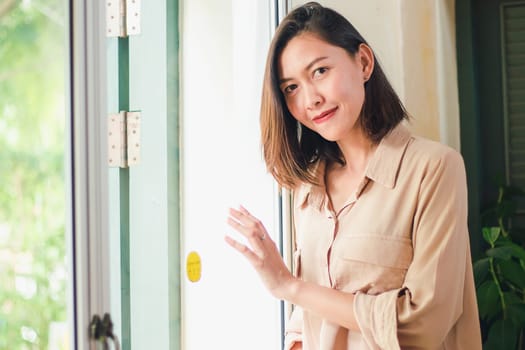 Women are standing against the wall with old wooden windows.