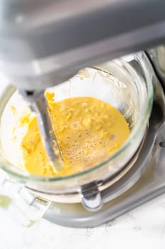 Mixing ingredients in kitchen mixer to bake mini Easter bread kulich.