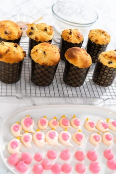 Glazing mini Easter bread kulich with a white lemon glaze.