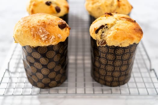 Cooling freshly baked mini Easter bread kulich on a kitchen counter.