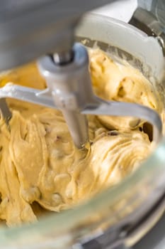 Mixing ingredients in kitchen mixer to bake mini Easter bread kulich.