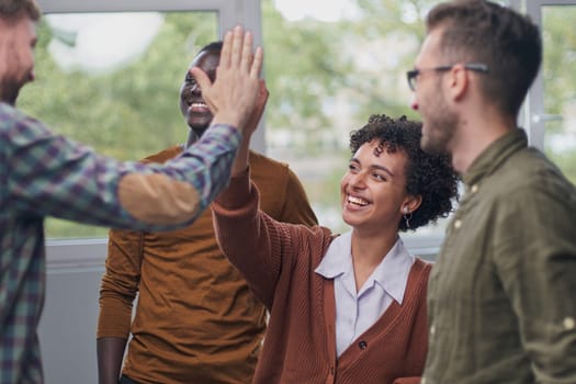 Group of businessman and businesswoman celebrating victory and teamspirit giving high five in air closeup