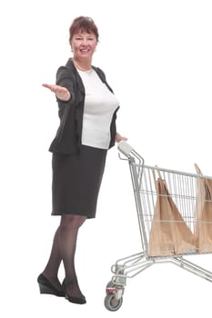 Full length portrait of a woman pushing a shopping trolley isolated on white background