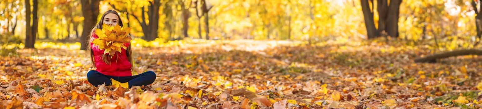 Autumn child in the park with yellow leaves. Selective focus. Kid.