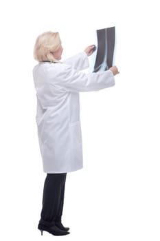 Side view of young professional female doctor examining patient's x-ray of human spine during a visit