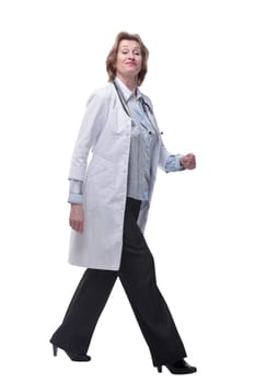 Mature female doctor walking towards the camera smiling isolated over a white background