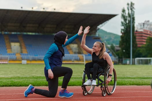 Two strong and inspiring women, one a Muslim wearing a burka and the other in a wheelchair stretching and preparing their bodies for a marathon race on the track.