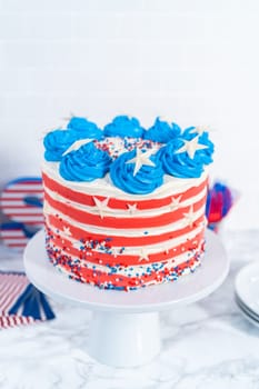 Decorating chocolate cake with white, red, and blue buttercream frosting for July 4th celebration.