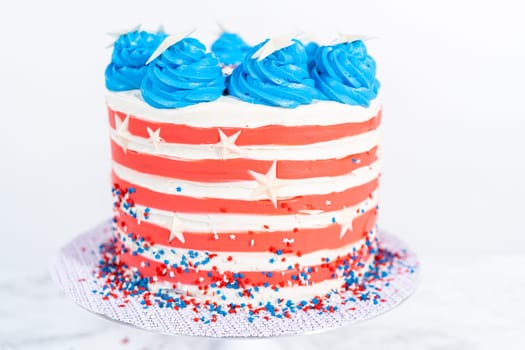 Decorating chocolate cake with white, red, and blue buttercream frosting for July 4th celebration.