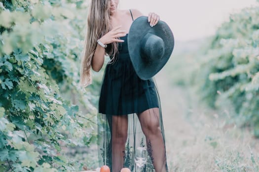 Woman at autumn winery. Portrait of happy woman holding glass of wine and enjoying in vineyard. Elegant young lady in hat toasting with wineglass smiling cheerfully enjoying her stay at vineyard